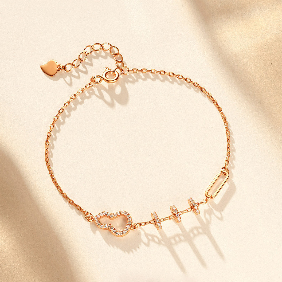 ChowTaiSeng rose gold gourd bracelet with adjustable chain and heart charm tag, overhead flat lay