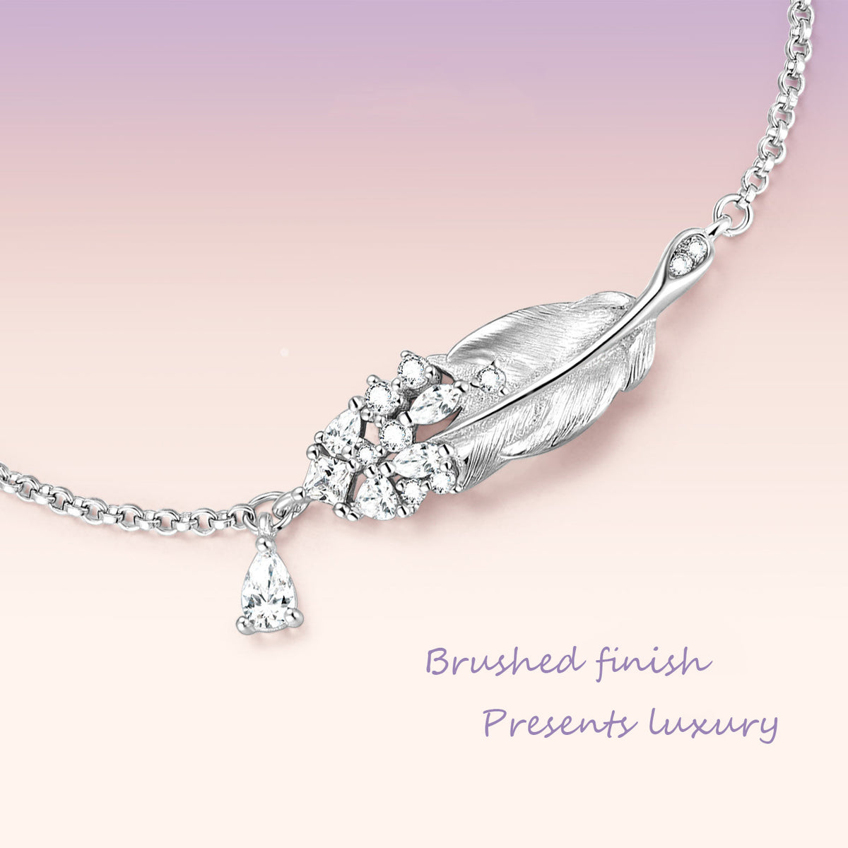 Close-up macro detail of sterling silver swan feather bracelet centerpiece showing brushed finish and sparkling cubic zirconia pave cluster with teardrop drop