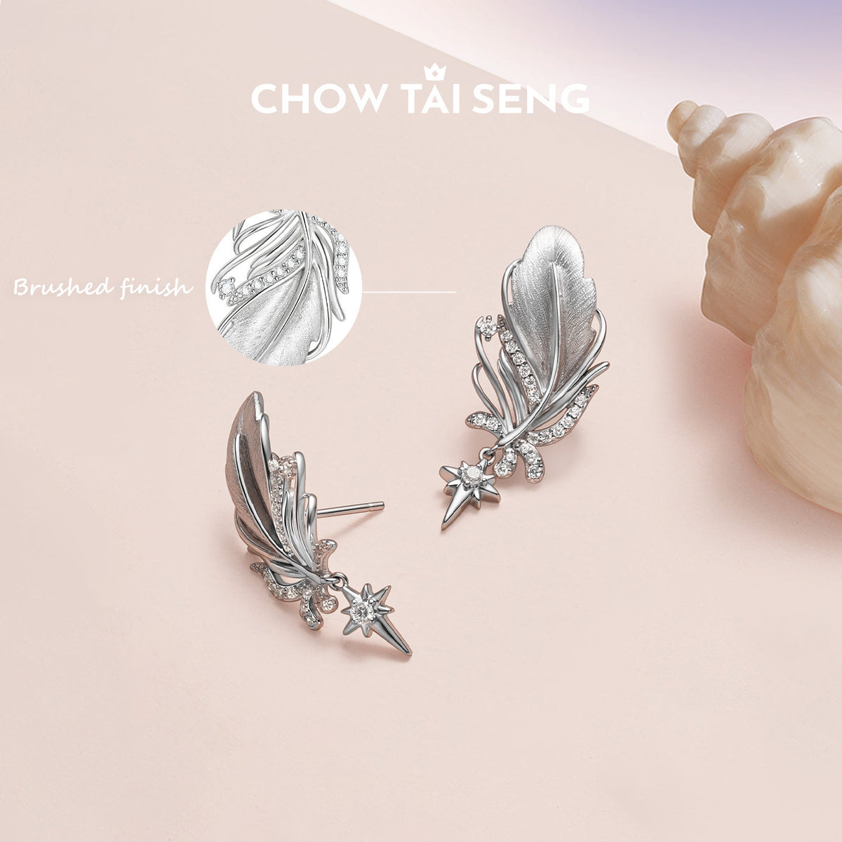 ChowTaiSeng sterling silver swan feather earrings with brushed finish detail and cubic zirconia pave, styled on pink surface with seashell