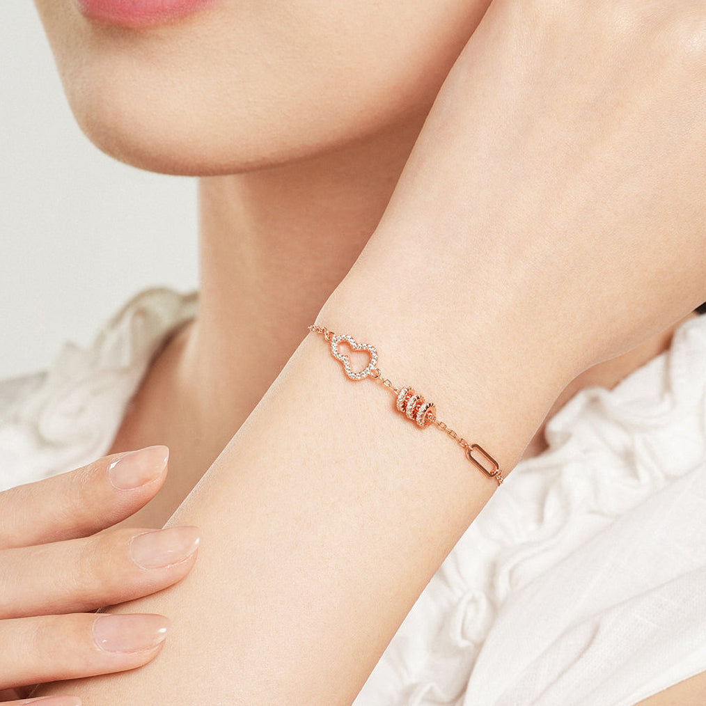 Woman wearing ChowTaiSeng rose gold zircon gourd waist bracelet on wrist, close-up lifestyle shot