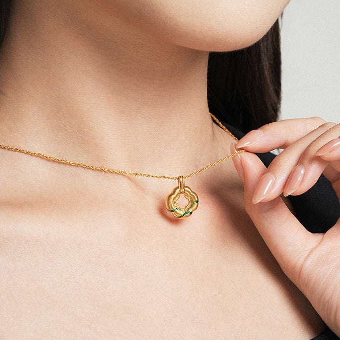 Model holding ChowTaiSeng 24K Gold Green Clover Pendant on gold chain, close-up lifestyle shot
