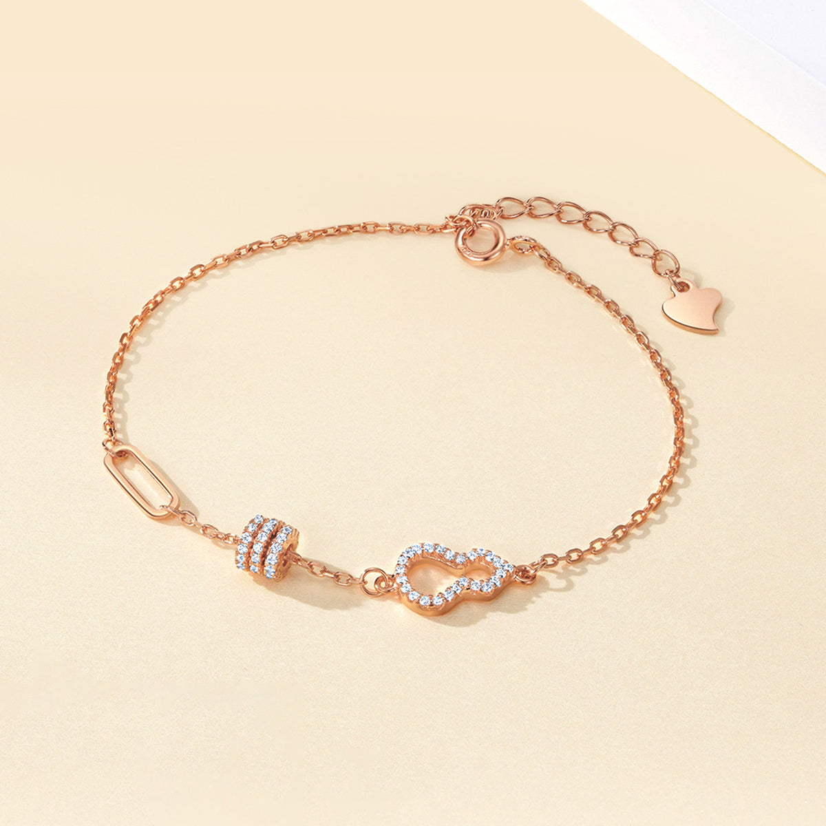ChowTaiSeng rose gold plated gourd waist bracelet with zirconia accents, flat lay on cream background