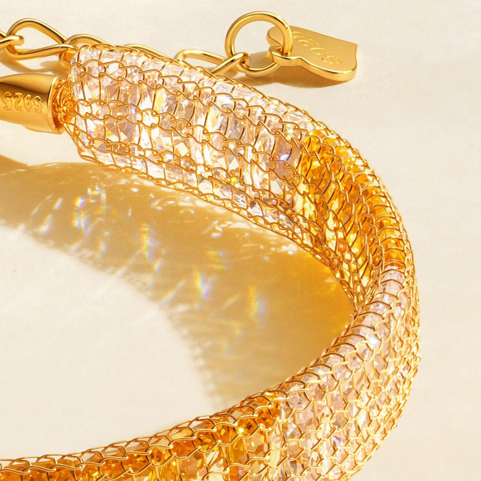 Close-up of cubic zirconia enclosed in gold-plated silver mesh, showing the bracelet extender and logo tag