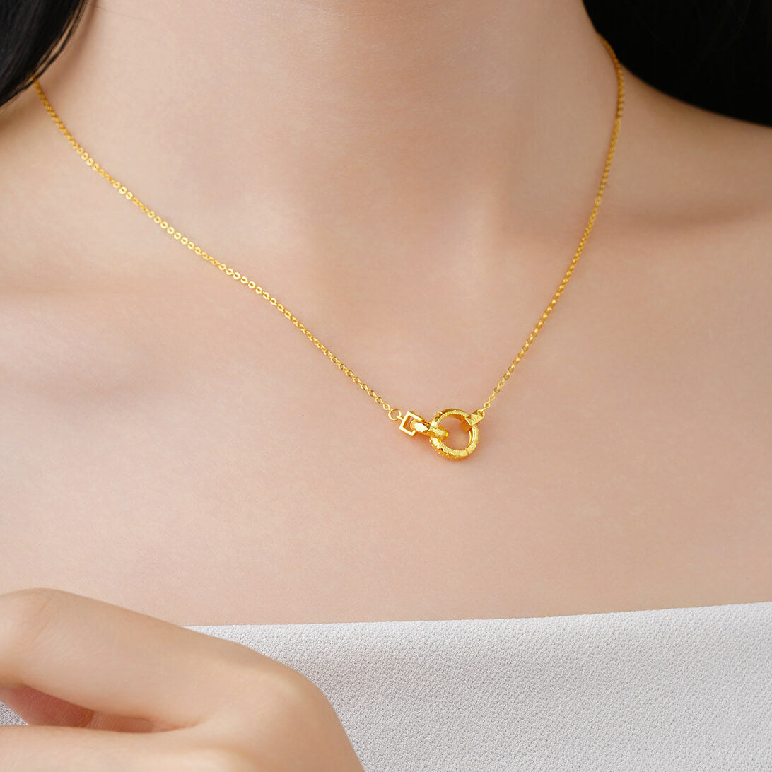 Model wearing a gold-plated silver interlocking circle necklace above a white strapless top