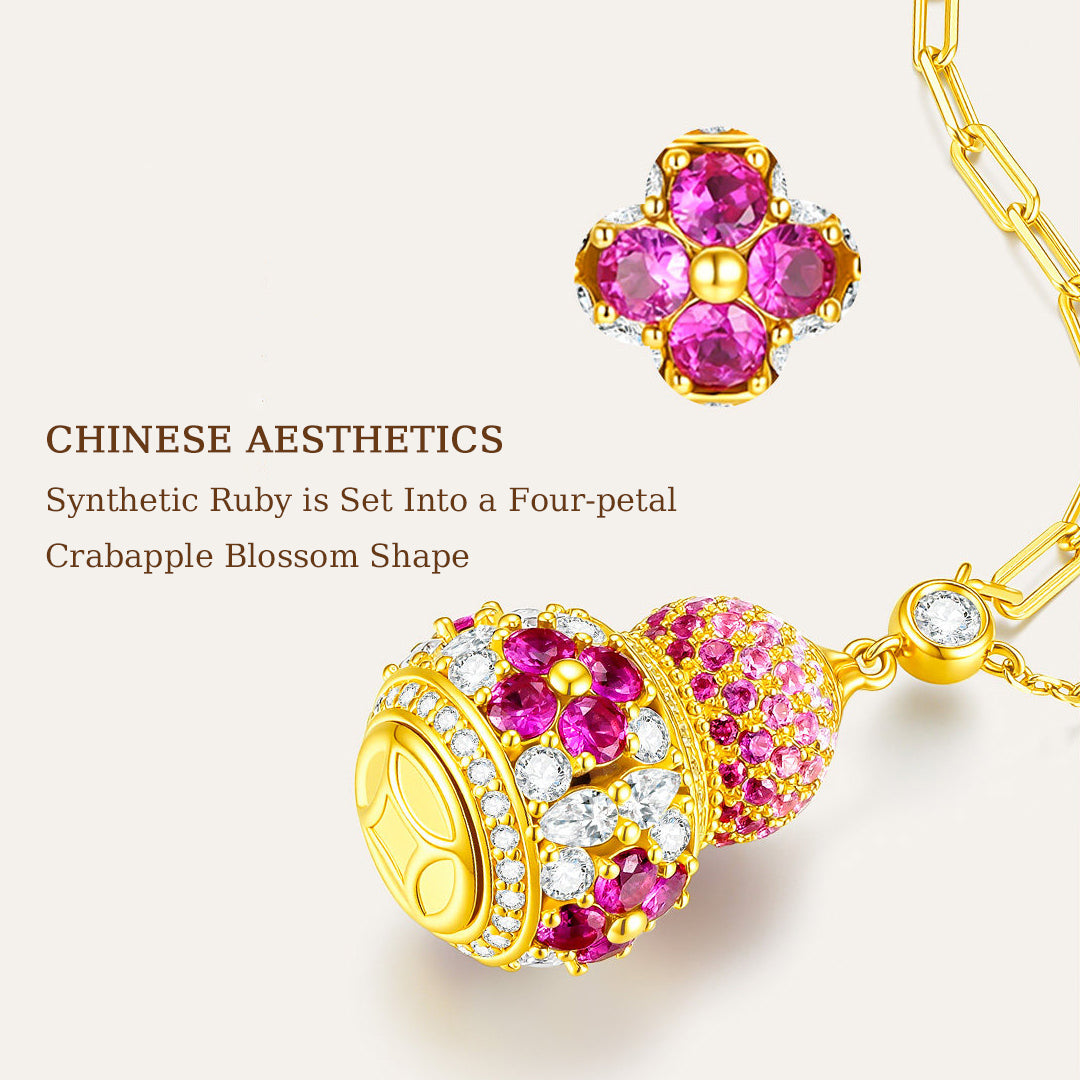 Close-up of synthetic ruby four-petal flowers and clear cubic zirconia on a gold-plated silver gourd pendant