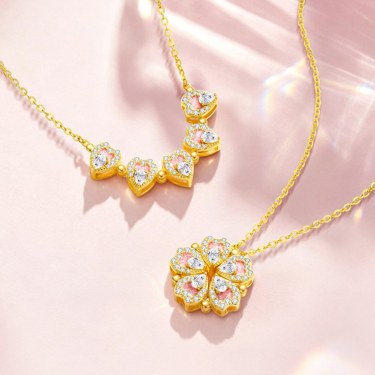 ChowTaiSeng gold plated silver peach blossom heart necklace styled beside real peach blossom flower on pink background — assembled flower pendant with pink enamel and CZ hearts on gold cable chain, "Peach Blossom" text overlay, floral editorial styling