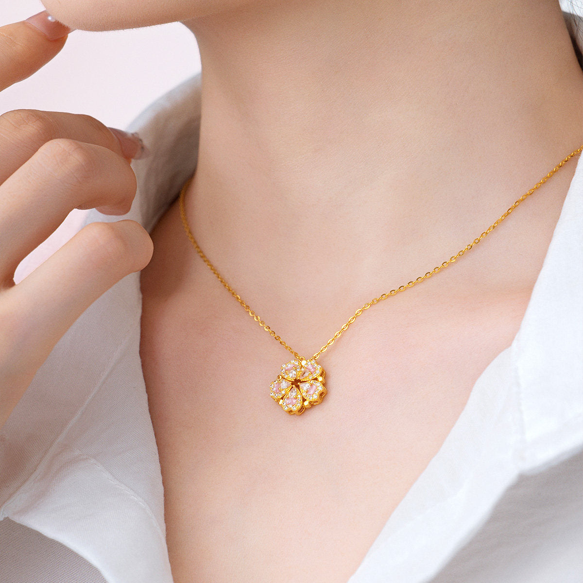 Close-up of model wearing ChowTaiSeng gold plated silver peach blossom necklace in assembled flower mode — five heart pendants with pink enamel petals and pear-cut white CZ stones forming a full floral pendant, gold cable chain at neckline