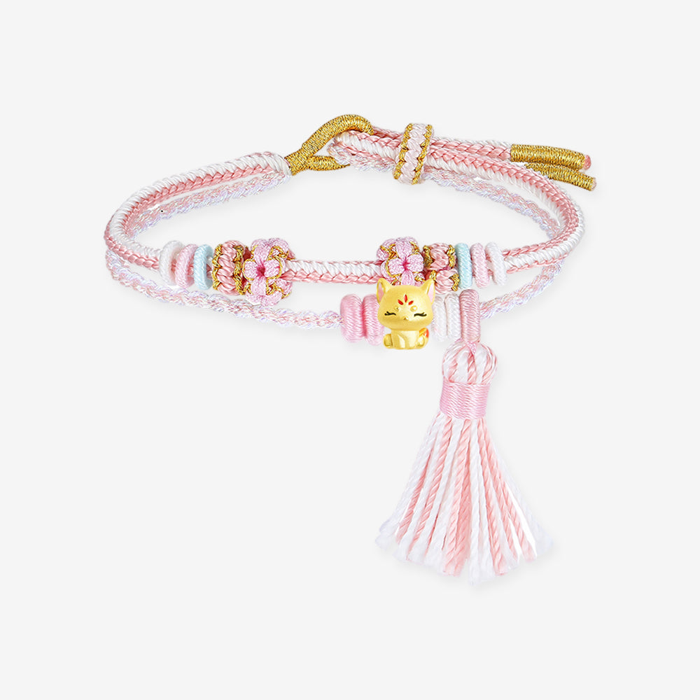 Full lay-flat view of ChowTaiSeng 24K gold lucky fox charm bracelet, pink and white braided cord with handmade sakura blossom knots, pastel spacer beads, gold fox charm and pink silk tassel, white background