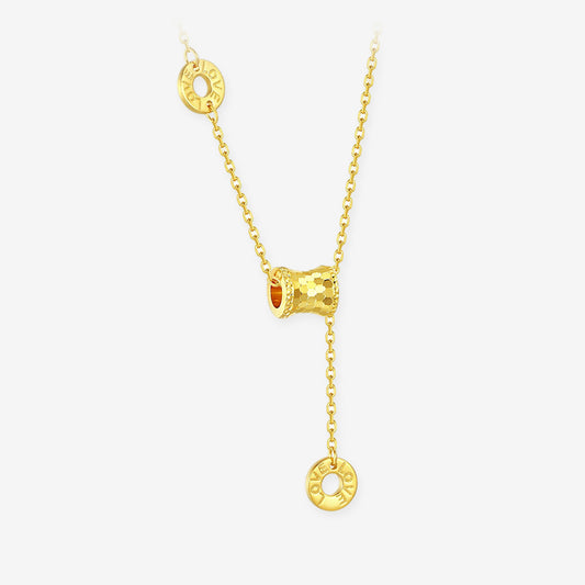 ChowTaiSeng gold lariat barrel necklace — full view, honeycomb diamond-cut barrel bead at centre with two LOVE openwork circle pendants on gold cable chain, white background